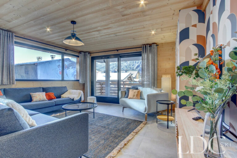 Bright lounge with doors opening onto the balcony and mountain views at Piste Bleue