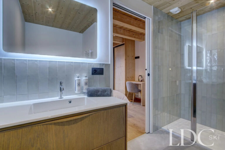 Piste Noire modern shower room with illuminated mirror and walk-in shower