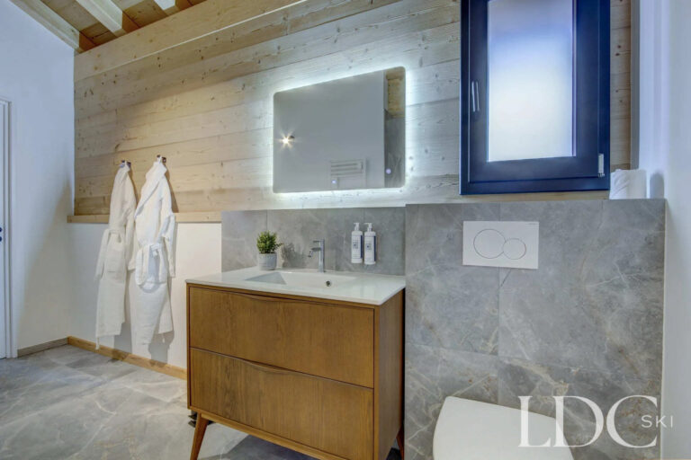 Piste Noire bathroom with timber vanity and contemporary stone-effect finish