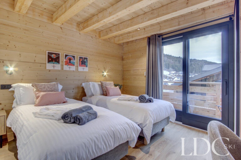 Piste Noire twin bedroom with timber interior and balcony access