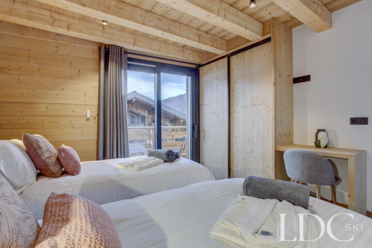 Piste Noire twin bedroom with timber walls and mountain-style interior