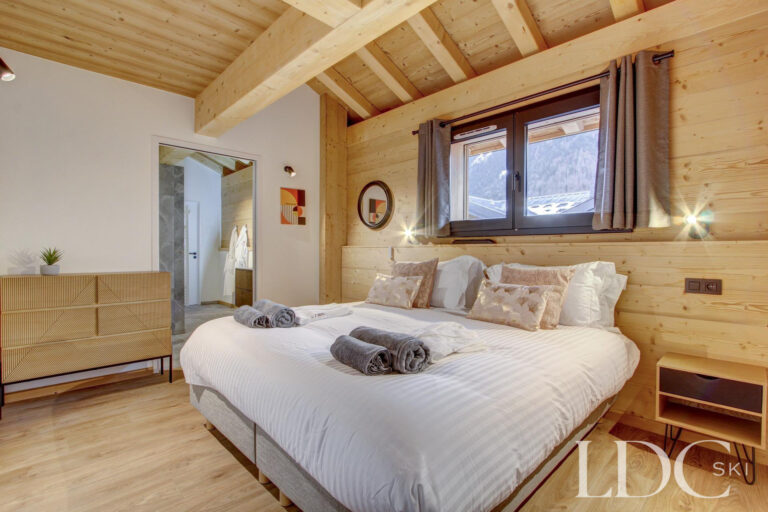 Piste Noire double bedroom with timber walls and contemporary alpine furnishings
