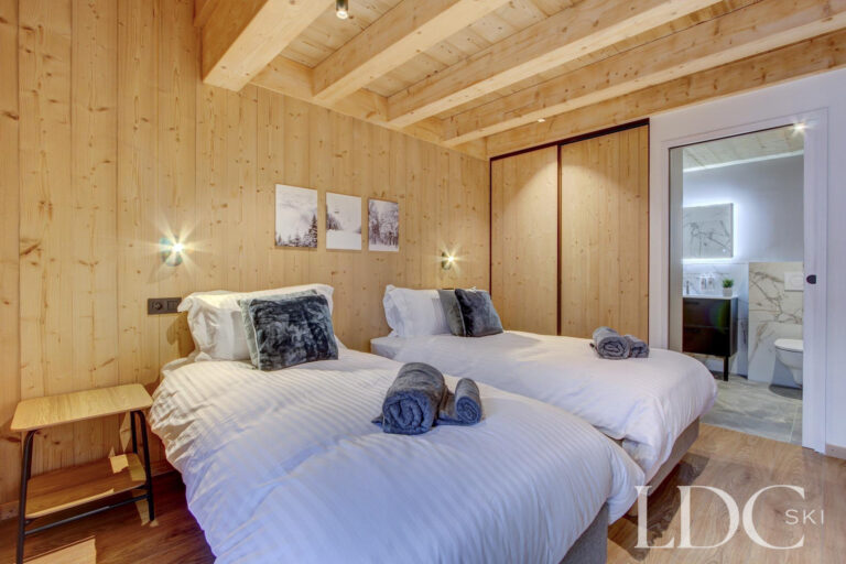 Piste Noire twin bedroom with timber interior and ensuite bathroom