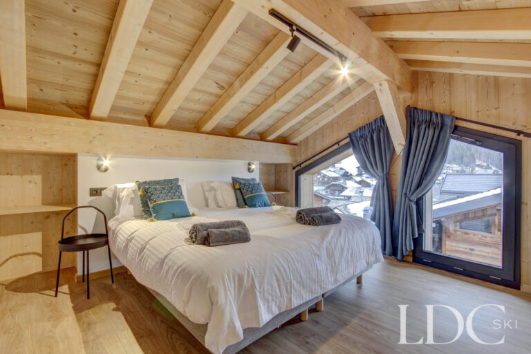 Piste Noire double bedroom with vaulted timber ceiling and panoramic mountain views