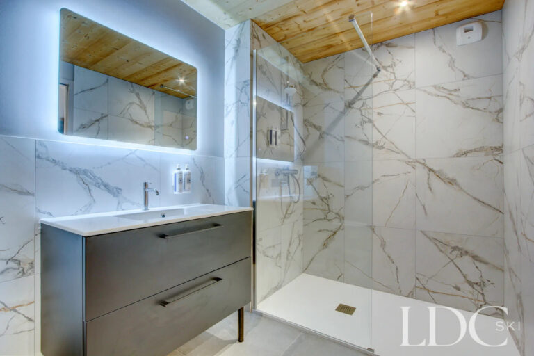 Piste Rouge shower room with marble-effect tiling