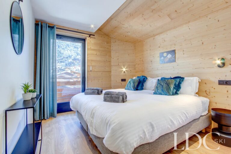 Piste Rouge double bedroom with timber-clad walls