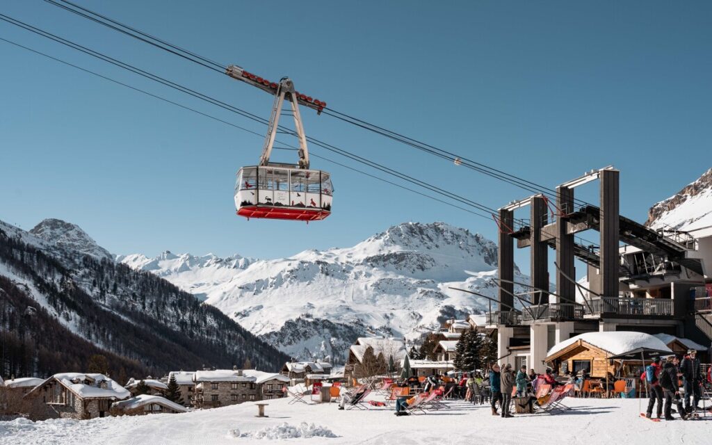 Gondola travelling above the snowy slopes with mountain views in Val d'Isère. © Yann Allègre
