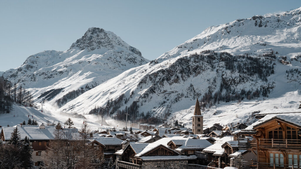 Winter view across Val d'Isère village with its church and snow-covered mountain backdrop. © Yann Allègre