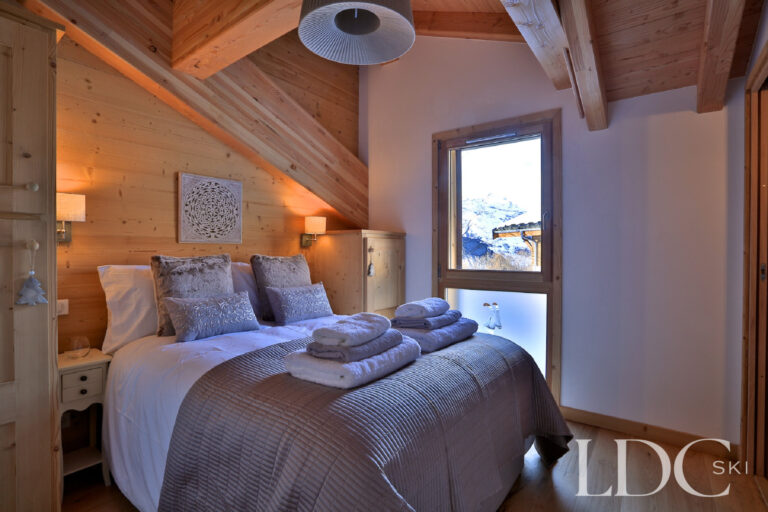 Double bedroom with timber ceiling and mountain view at Chalet Aphylla