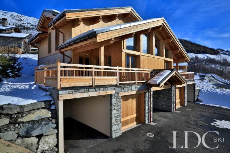 Snowy exterior of Chalet Aphylla showing its timber terrace in St Martin de Belleville
