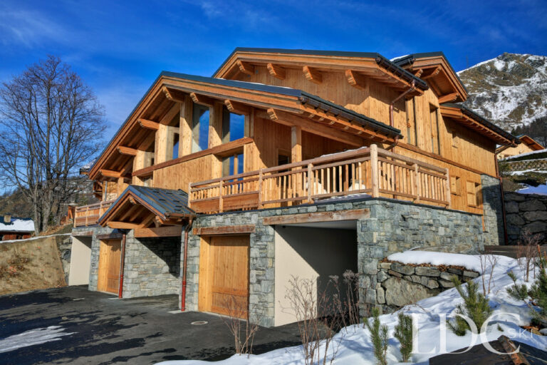 Side view of Chalet Aphylla with its timber balconies and stonework in St Martin de Belleville