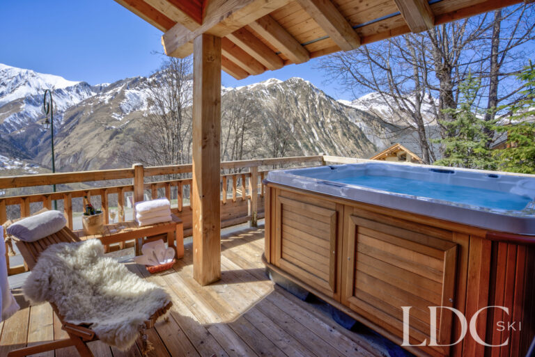 Private outdoor hot tub on the covered terrace with mountain views at Chalet Aphylla