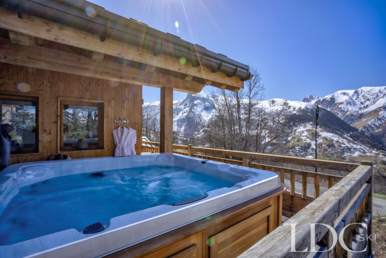 Private outdoor hot tub overlooking the snowy mountains at Chalet Aphylla