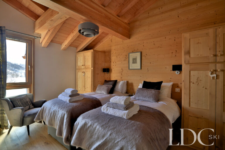 Twin bedroom with exposed timber ceiling at Chalet Aralia