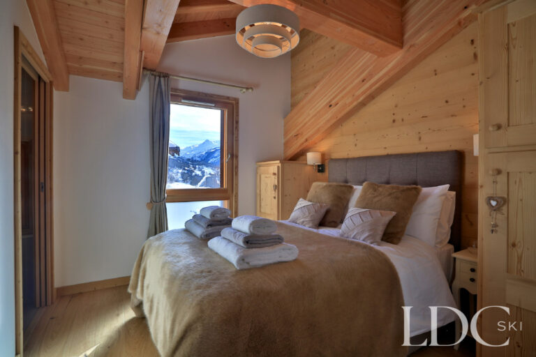 Double bedroom with timber finishes at Chalet Aralia