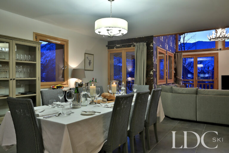 Dining area prepared for dinner beside the living room at Chalet Aralia