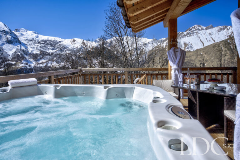 Bubbling outdoor hot tub with mountain views at Chalet Aralia
