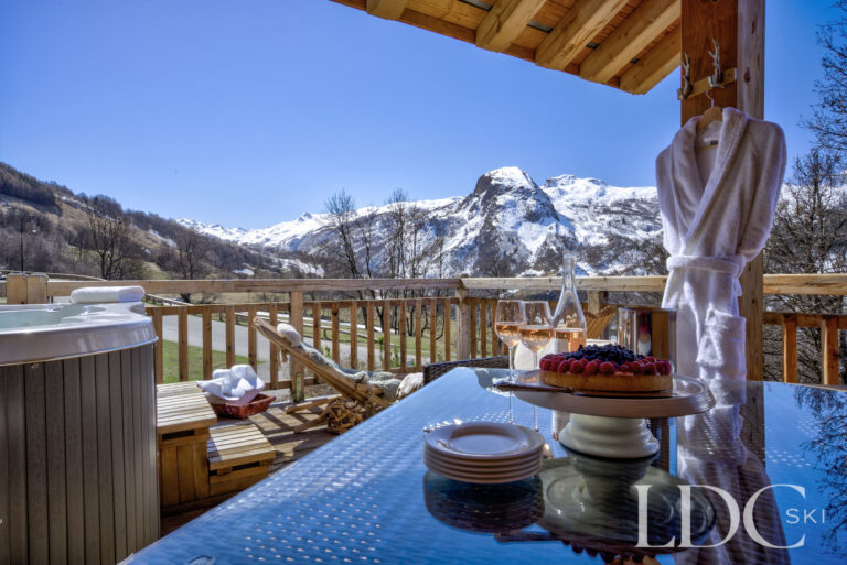 Private hot tub and terrace seating with panoramic mountain views at Chalet Aralia
