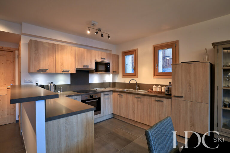 Contemporary kitchen with timber cabinetry and breakfast bar at Chalet Aralia