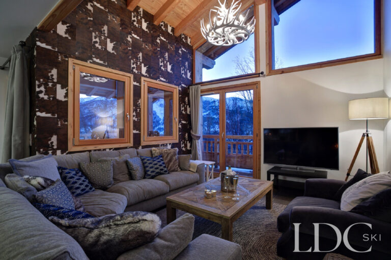 Cosy living room with fireplace and evening mountain views at Chalet Aralia