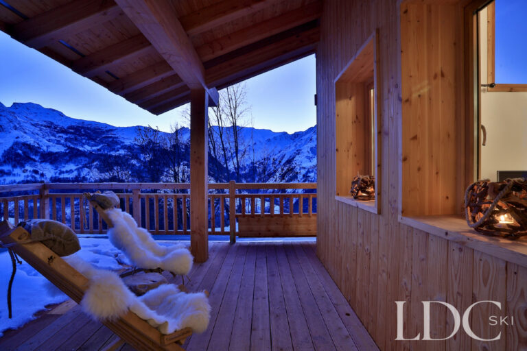 Covered terrace overlooking the mountains at dusk at Chalet Aralia
