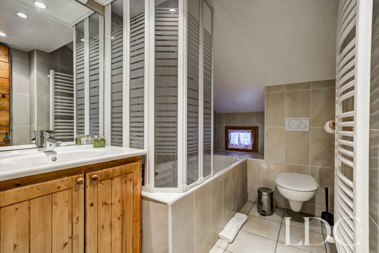 En-suite bathroom with bath and shower at Chalet Cecilia