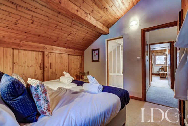 Double bedroom with timber ceiling and en-suite bathroom at Chalet Cecilia
