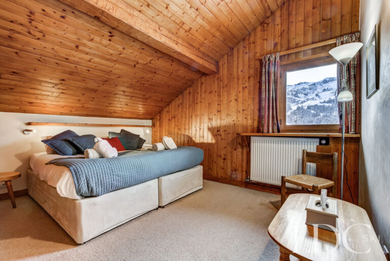 Double bedroom beneath a timber ceiling with mountain views at Chalet Cecilia