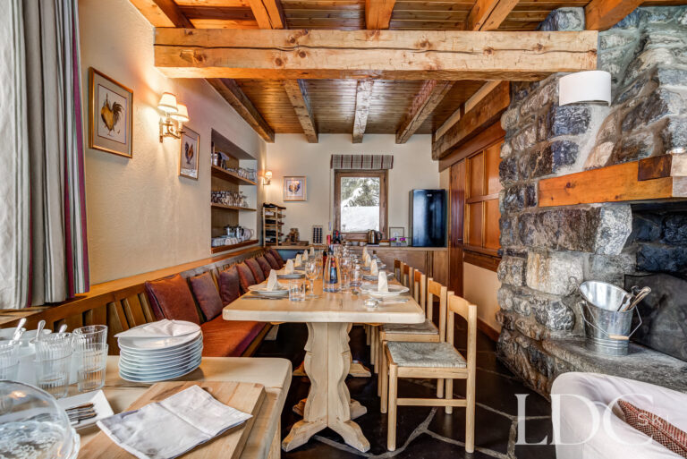 Traditional chalet dining room with exposed timber beams and stone fireplace at Chalet Cecilia