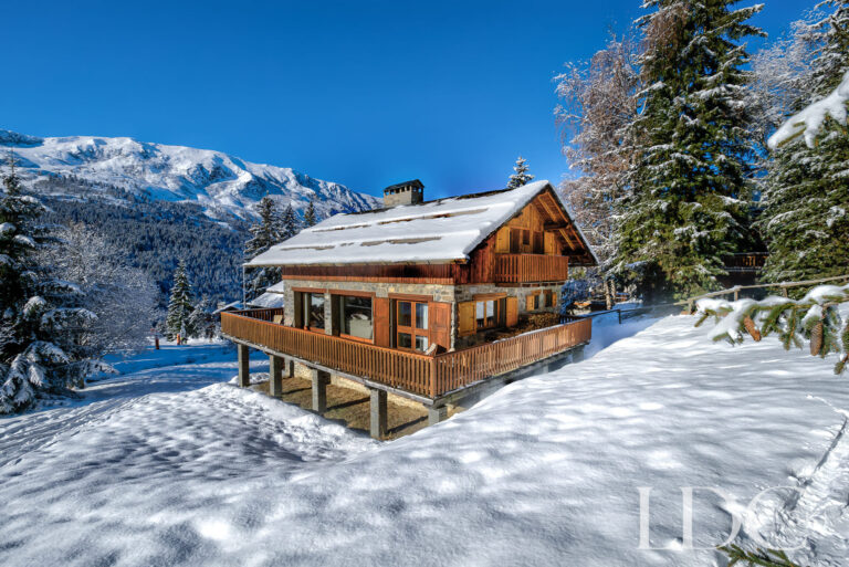 Chalet Cecilia surrounded by deep snow beneath a clear blue sky in Méribel