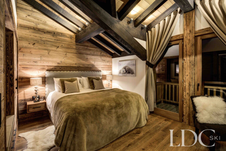 Characterful double bedroom beneath exposed timber beams at Chalet Chez Bugi