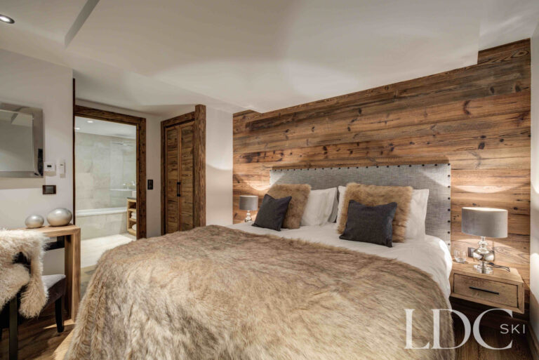 Double bedroom with adjoining ensuite bathroom at Chalet Chez Bugi