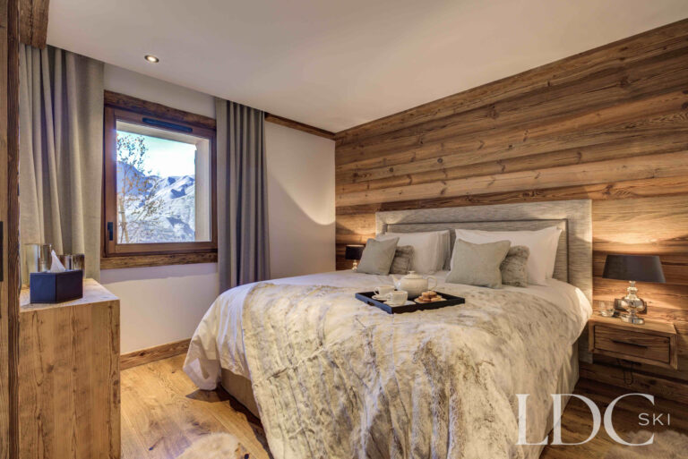 Super king bedroom with warm timber detailing and mountain-inspired furnishings at Chalet Chez Bugi