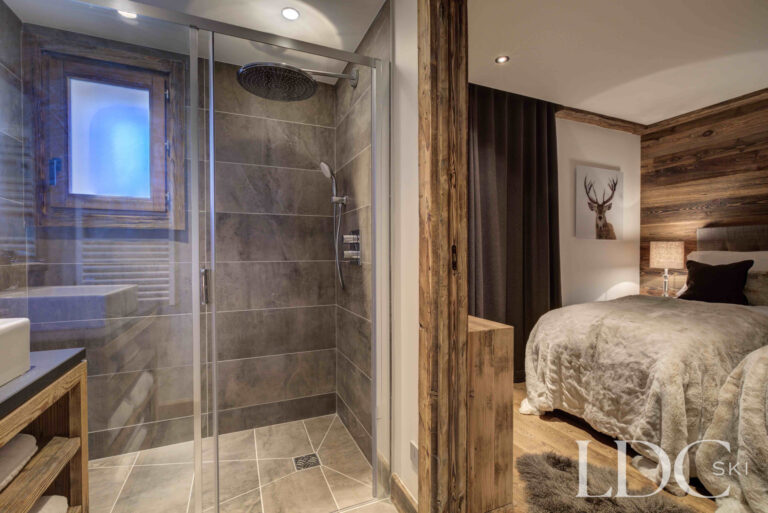 Bedroom 5 arranged as a twin with adjoining ensuite bathroom at Chalet Chez Bugi