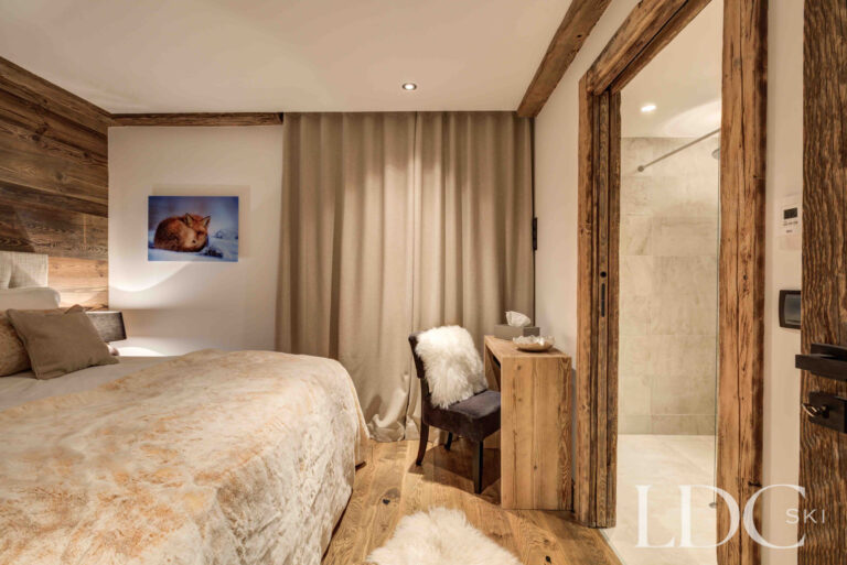 Super king bedroom with warm timber detailing at Chalet Chez Bugi