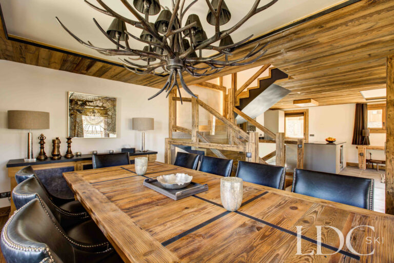 Large wooden dining table beside the open kitchen at Chalet Chez Bugi
