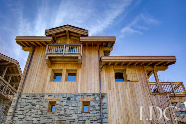 Timber and stone exterior of Chalet Chez Bugi beneath the mountains in St Martin de Belleville