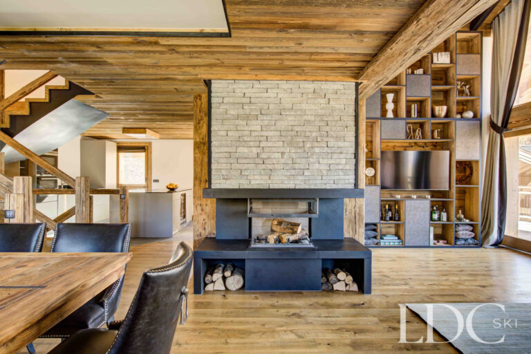 Double-sided stone fireplace dividing the living spaces at Chalet Chez Bugi
