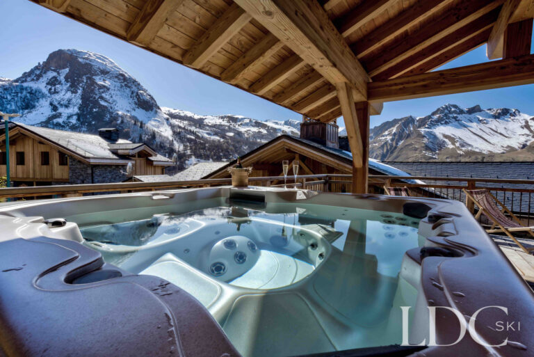 Outdoor hot tub overlooking the dramatic mountain scenery at Chalet Chez Bugi