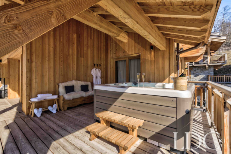 Private outdoor hot tub on the covered terrace at Chalet Chez Bugi