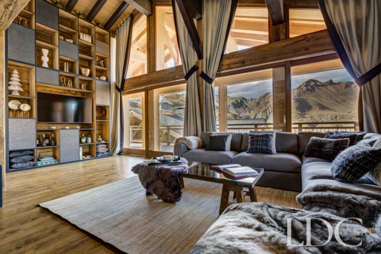 Impressive timber-framed living room with large windows and mountain views at Chalet Chez Bugi