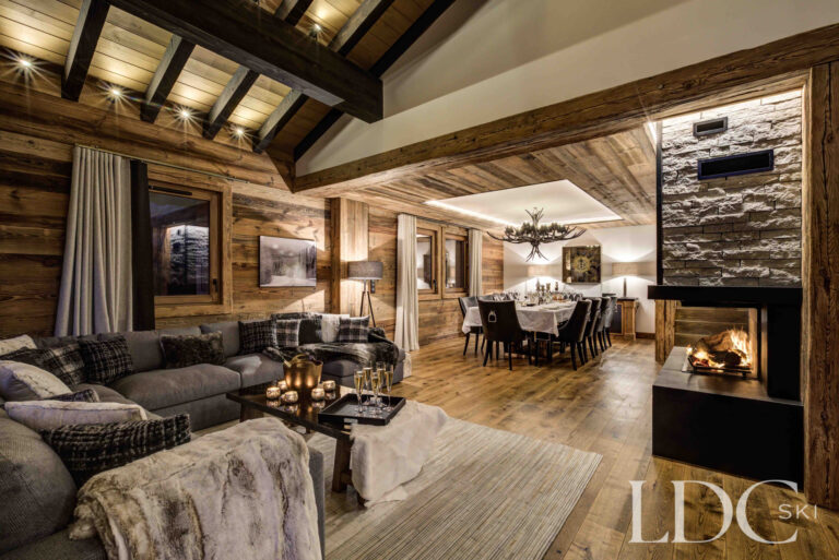 Open-plan living and dining space with fireplace at Chalet Chez Bugi