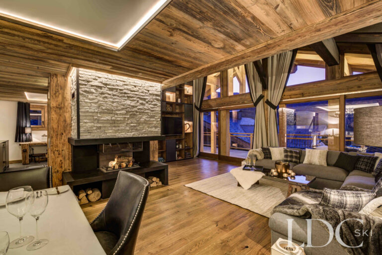 Chalet Chez Bugi's living room glowing warmly against the evening mountain views