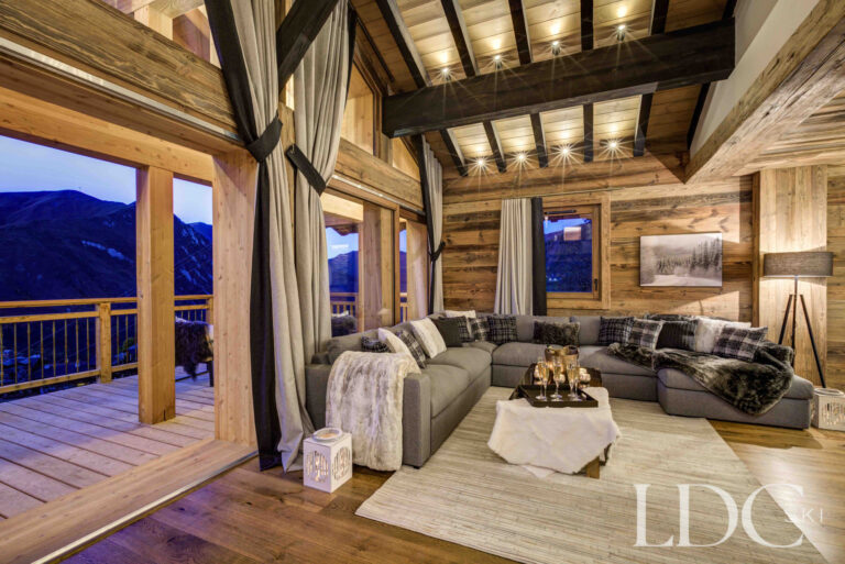 Living room opening onto the terrace with evening mountain views at Chalet Chez Bugi