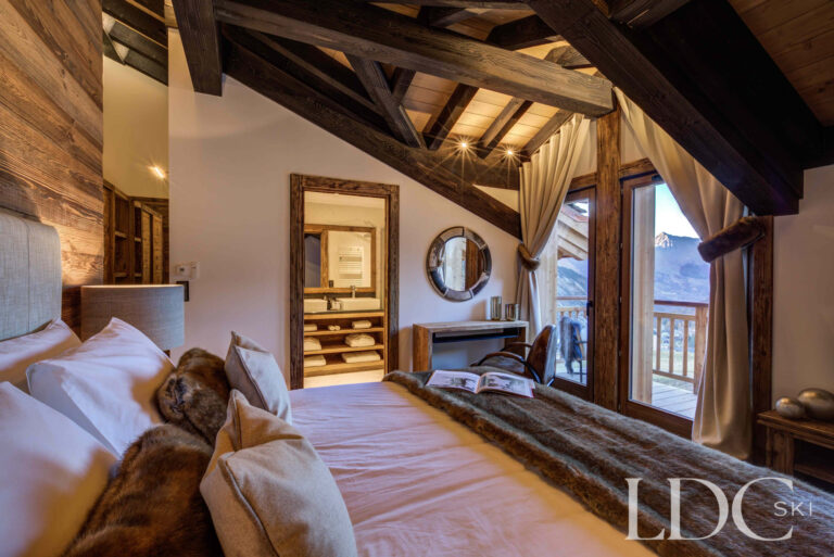 Spacious master bedroom beneath a vaulted timber ceiling at Chalet Chez Bugi