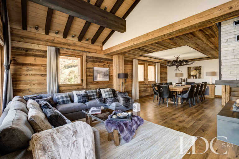 Spacious open-plan living and dining area with exposed timber at Chalet Chez Bugi