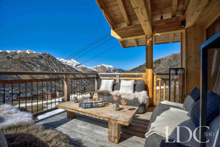 Sunny terrace with seating and panoramic mountain views at Chalet Chez Bugi