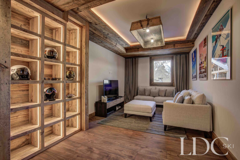 Cosy separate TV snug with timber shelving at Chalet Chez Bugi