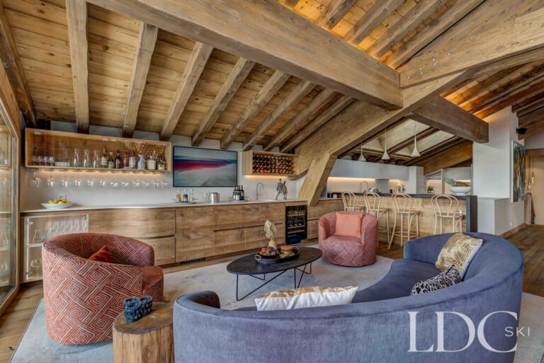 Private bar with relaxed seating beneath exposed timber beams at Chalet Constantia