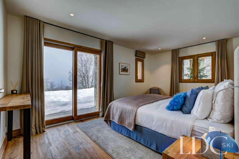 Double bedroom with balcony doors and snowy views at Chalet Constantia